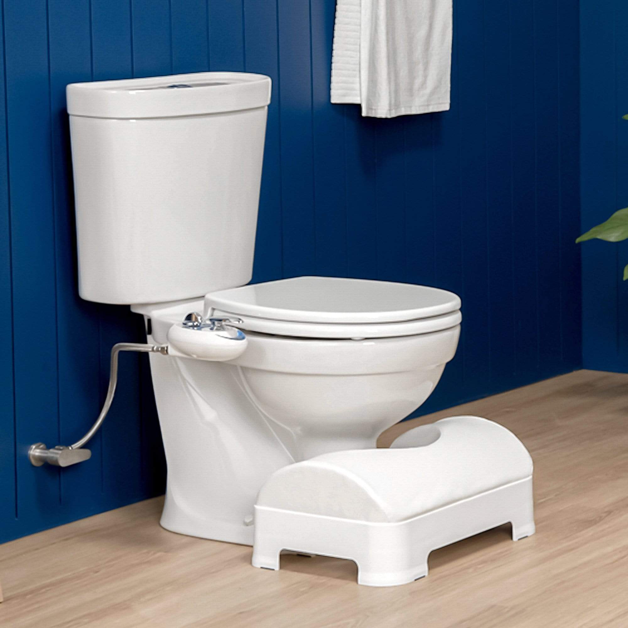 LUXE Footstool in front of a toilet with a NEO bidet installed, in wooden and blue bathroom