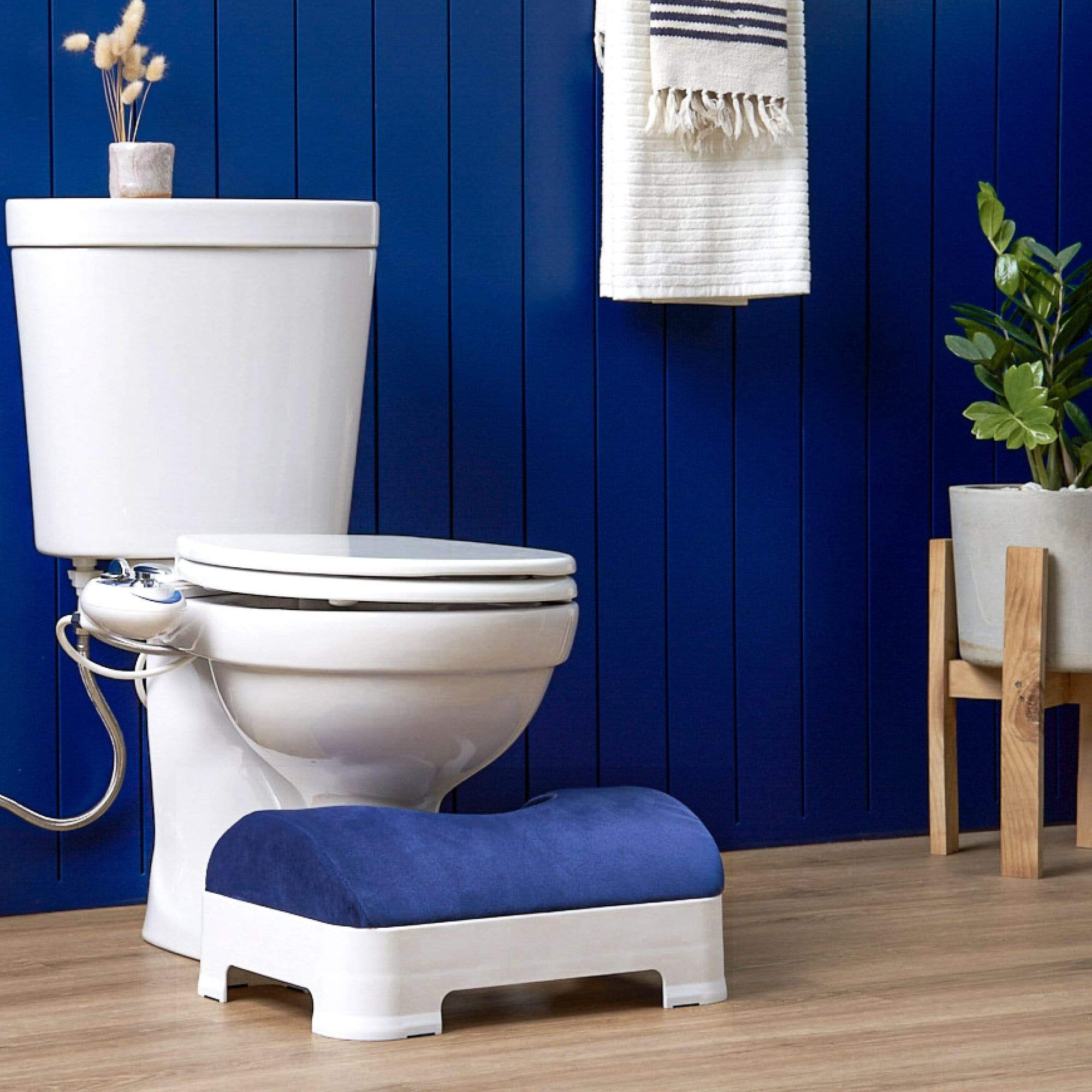 LUXE Footstool: Velour Covers - Navy Blue - Footstool is tucked into toilet in a modern bathroom