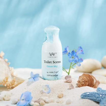 60 mL Ocean Mist Whift Toilet Scents Spray on a pile of sand with flowers and shells